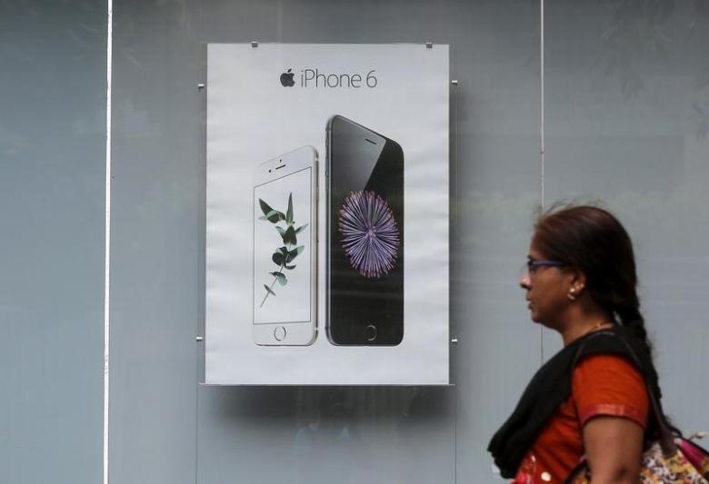 A pedestrian walks past an Apple iPhone 6 advertisement at an electronics store in Mumbai, India, July 24, 2015. REUTERS/Shailesh Andrade/File Photo